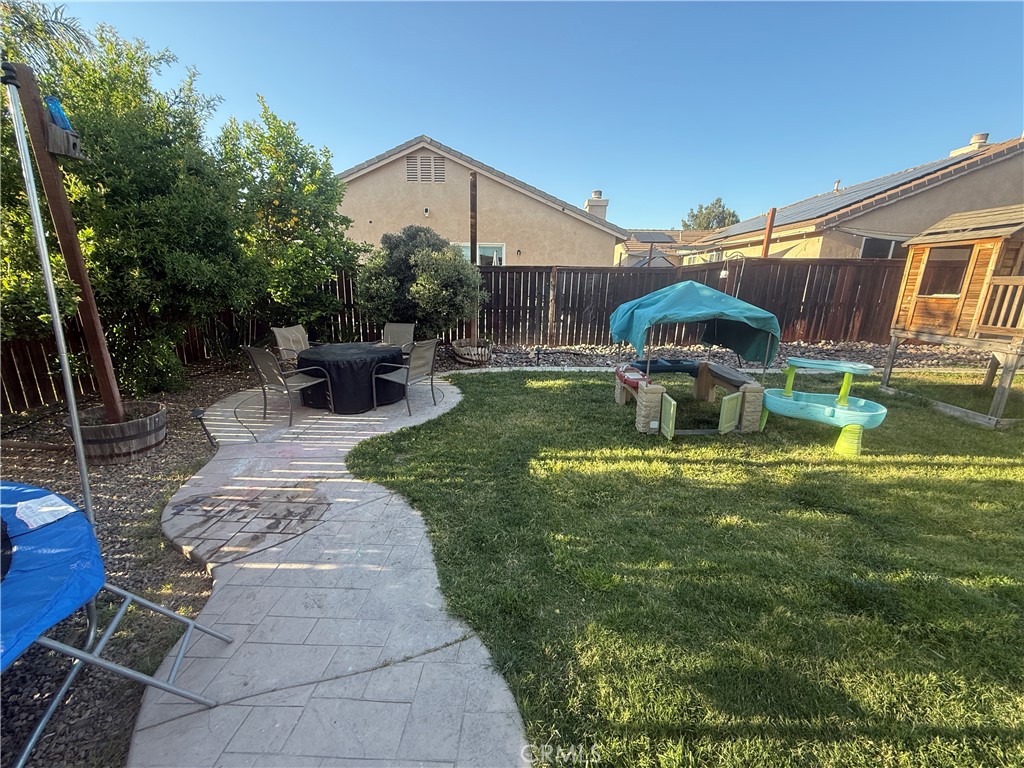 30130 Pine Needle Road Menifee, CA 92585 - Photo 45 of 45 a view of a backyard with couches table and chairs under an umbrella
