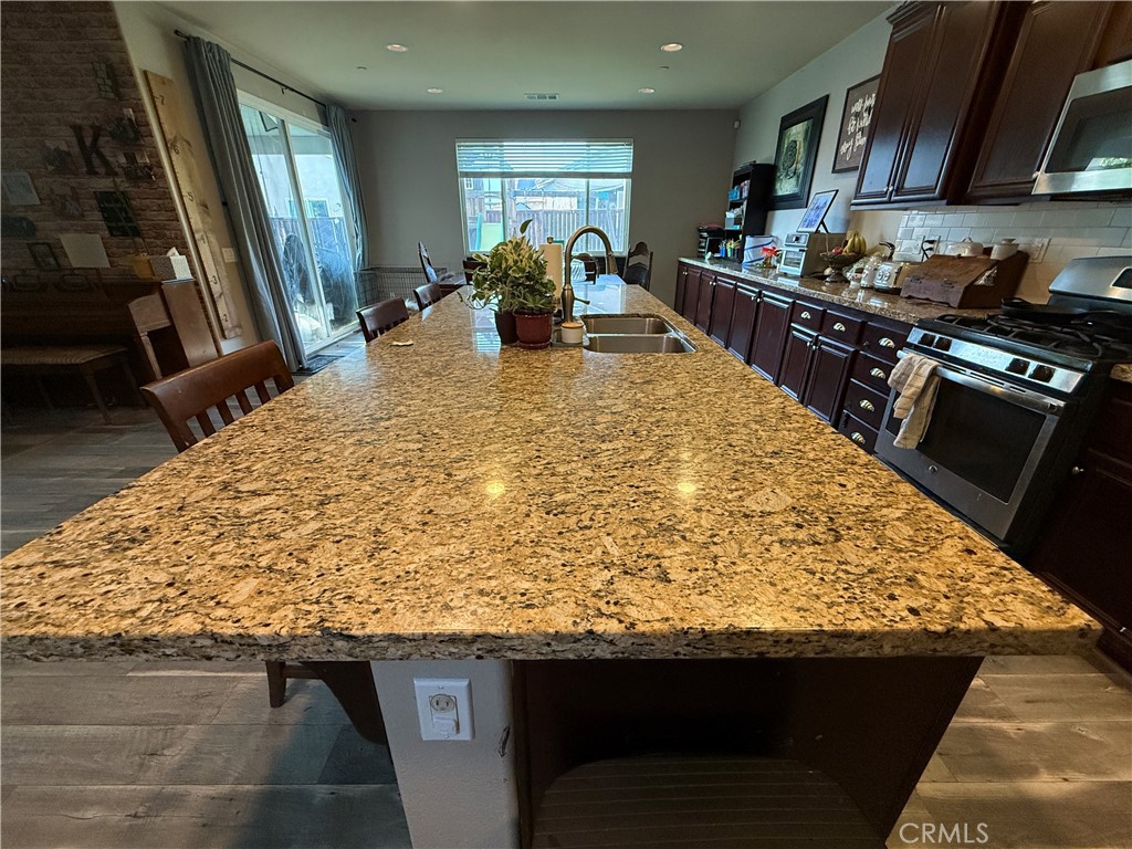 30130 Pine Needle Road Menifee, CA 92585 - Photo 6 of 45 a kitchen with kitchen island granite countertop a sink counter top space and stainless steel appliances