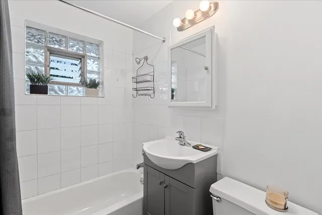a bathroom with a sink mirror vanity and toilet