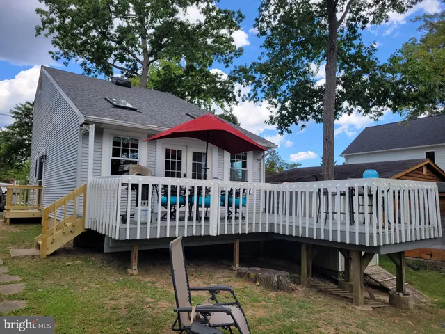 a view of a house with a wooden deck and a yard