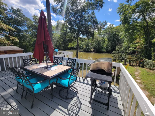 a view of a patio with wooden floor table and chairs