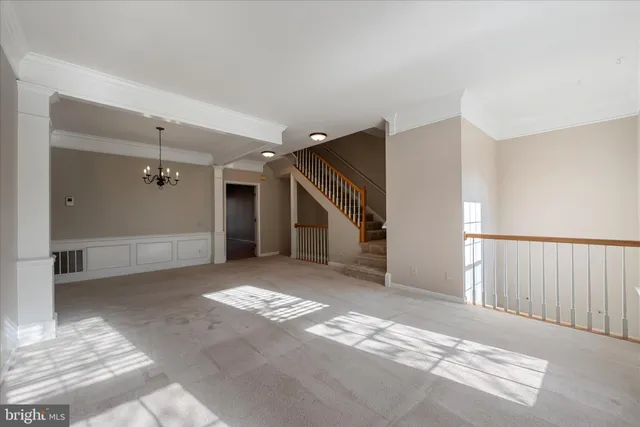 a view of a room with wooden floor and a ceiling fan