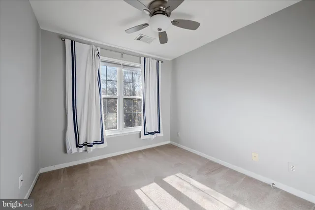 an empty room with fireplace and fan