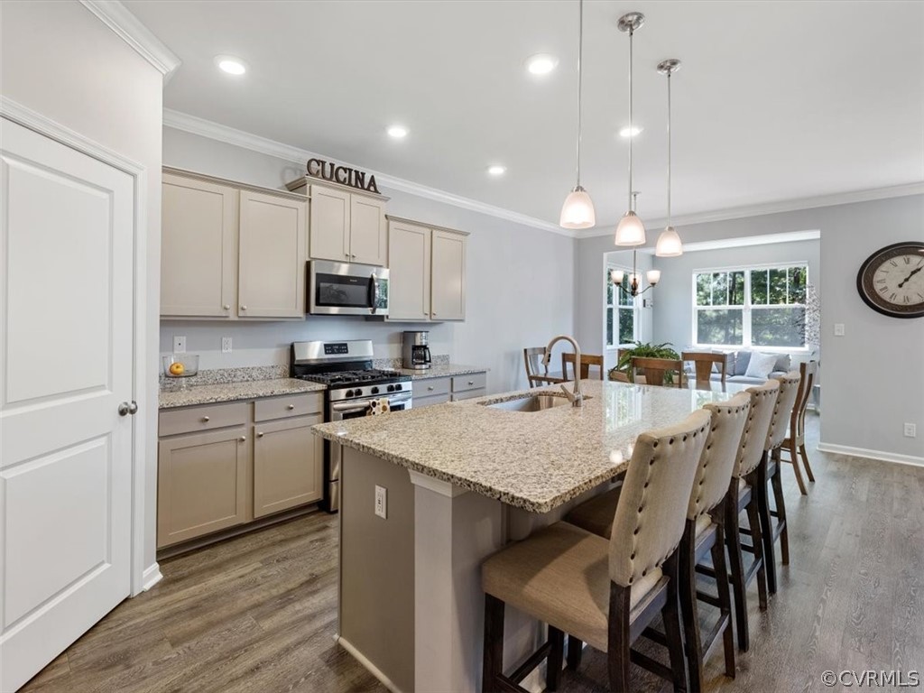 1413 Braisden Road Midlothian, VA 23114 - Photo 8 of 37 a kitchen with stainless steel appliances granite countertop a stove a refrigerator a microwave a dining table and chairs with wooden floor