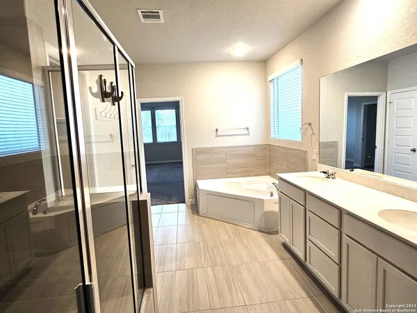 a bathroom with a tub sink and mirror