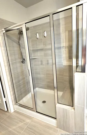a bathroom with a glass shower door and mirror