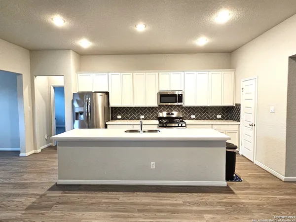 a view of kitchen cabinets stainless steel appliances and window