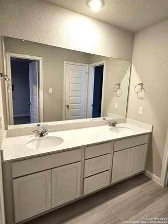 a bathroom with a double vanity sink and a mirror