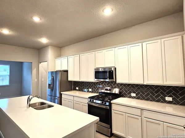 a kitchen with sink a stove and refrigerator