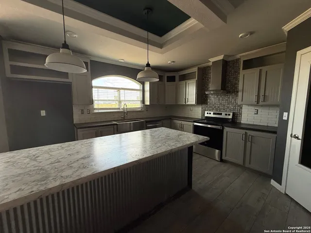 a view of a big room with wooden floor and electronic appliances