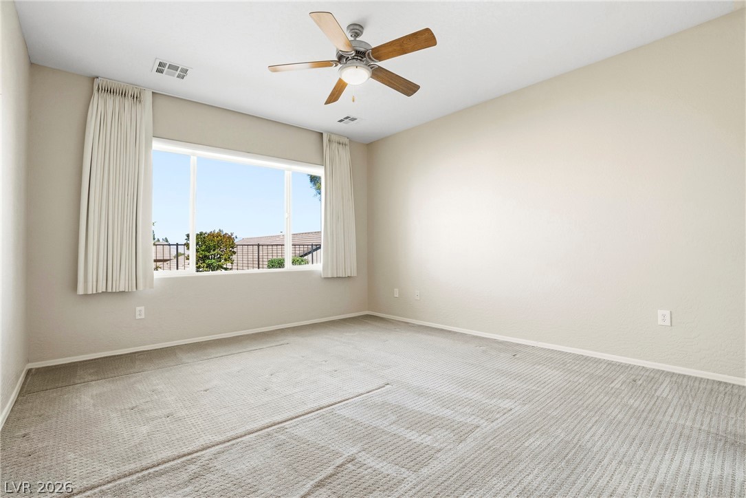 2541 Darda Street Henderson, NV 89044 - Photo 15 of 26 This spacious bedroom offers ample natural light and comfortable carpeting throughout.