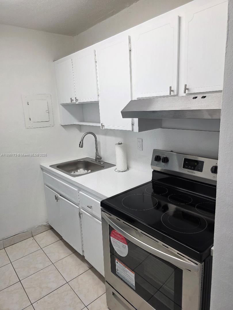 677 Southwest 9th Avenue, Unit 205 Miami, FL 33130 - Photo 9 of 27 a kitchen with stainless steel appliances a stove and white cabinets