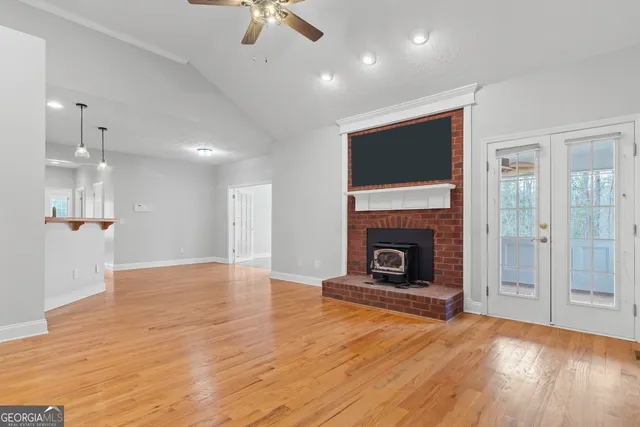 wooden floor fireplace and windows in an empty room