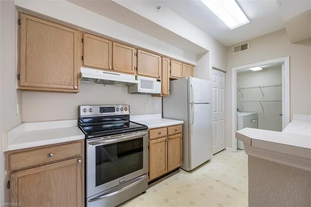 a kitchen with refrigerator a stove and cabinets