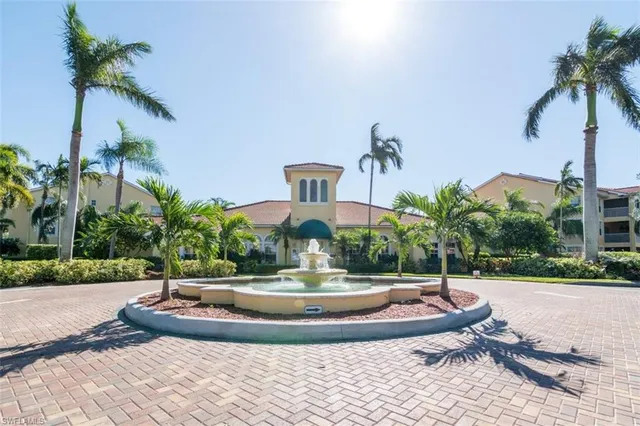 a view of a swimming pool with a yard and palm trees