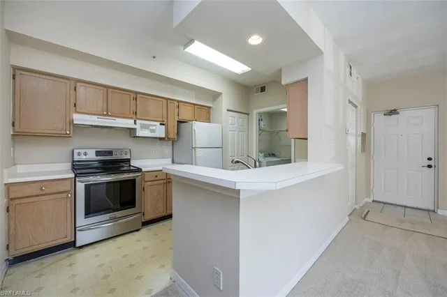 a kitchen with stainless steel appliances kitchen island a sink stove and cabinets
