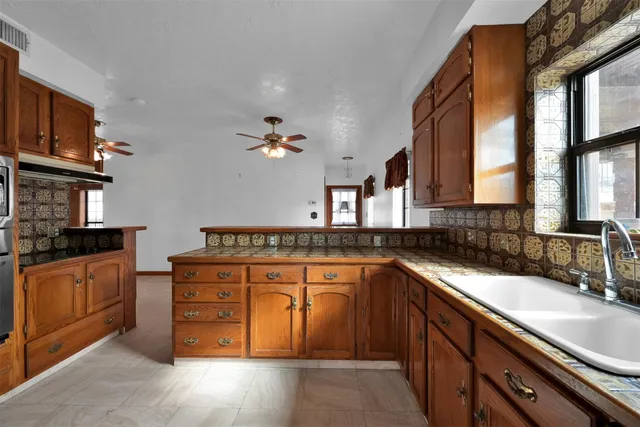 a kitchen with stainless steel appliances granite countertop a sink stove and cabinets