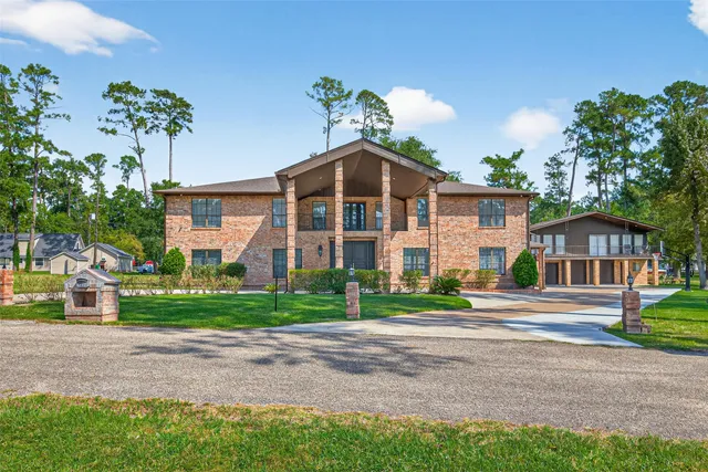 a front view of a house with a yard and trees