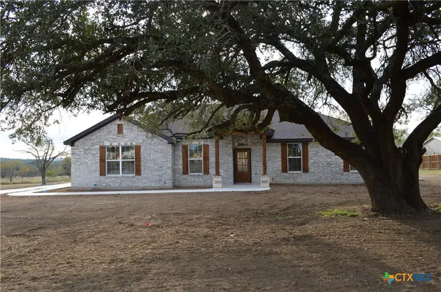 a house that has a tree in front of a white house