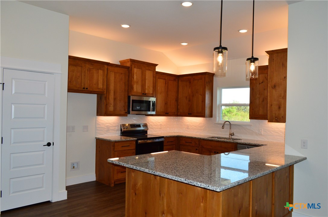 425 County Road 3152 Kempner, TX 76539 - Photo 14 of 48 a kitchen with kitchen island granite countertop a sink a counter top space appliances and cabinets