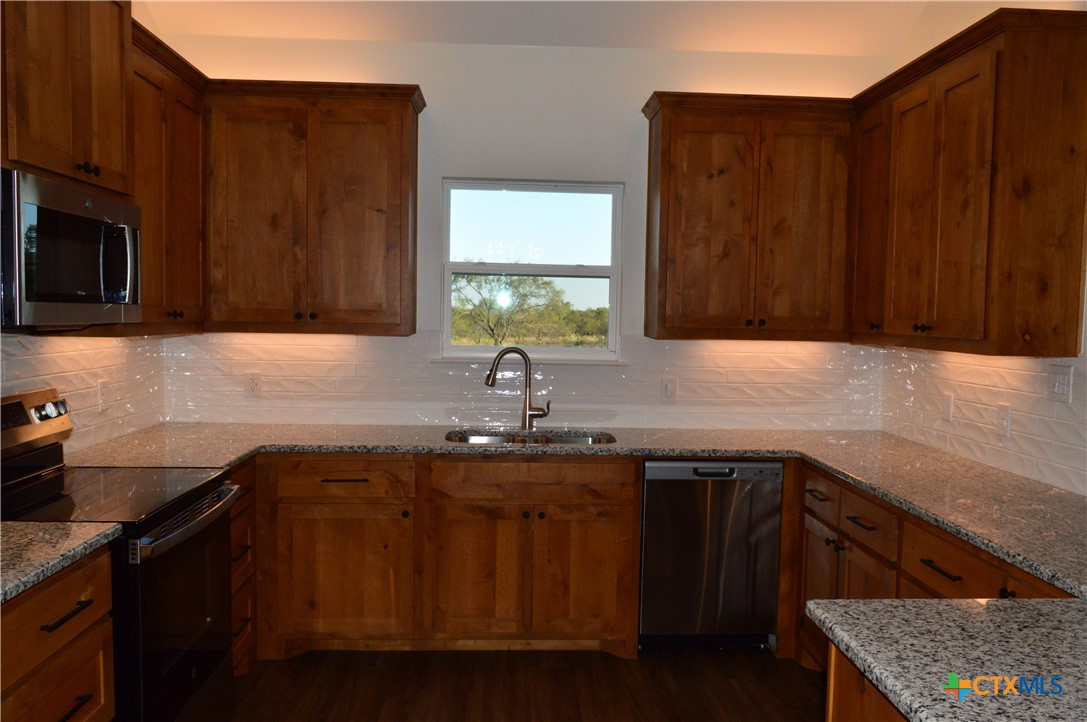 425 County Road 3152 Kempner, TX 76539 - Photo 15 of 48 a kitchen with stainless steel appliances granite countertop a sink stove and microwave