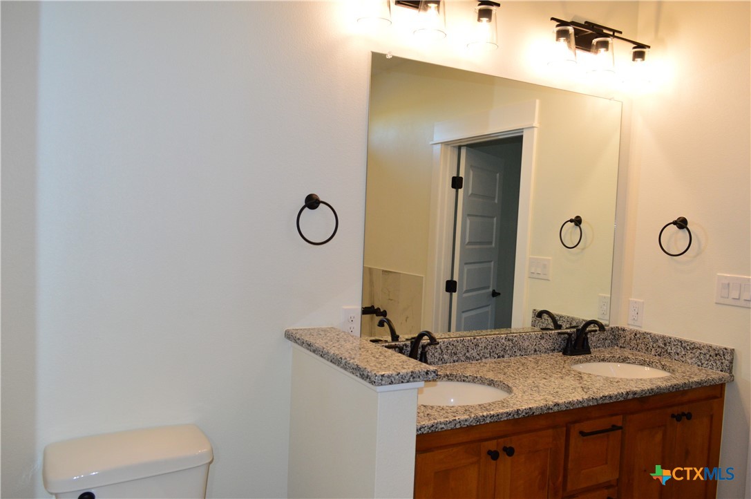 425 County Road 3152 Kempner, TX 76539 - Photo 26 of 48 a bathroom with a granite countertop sink and a mirror