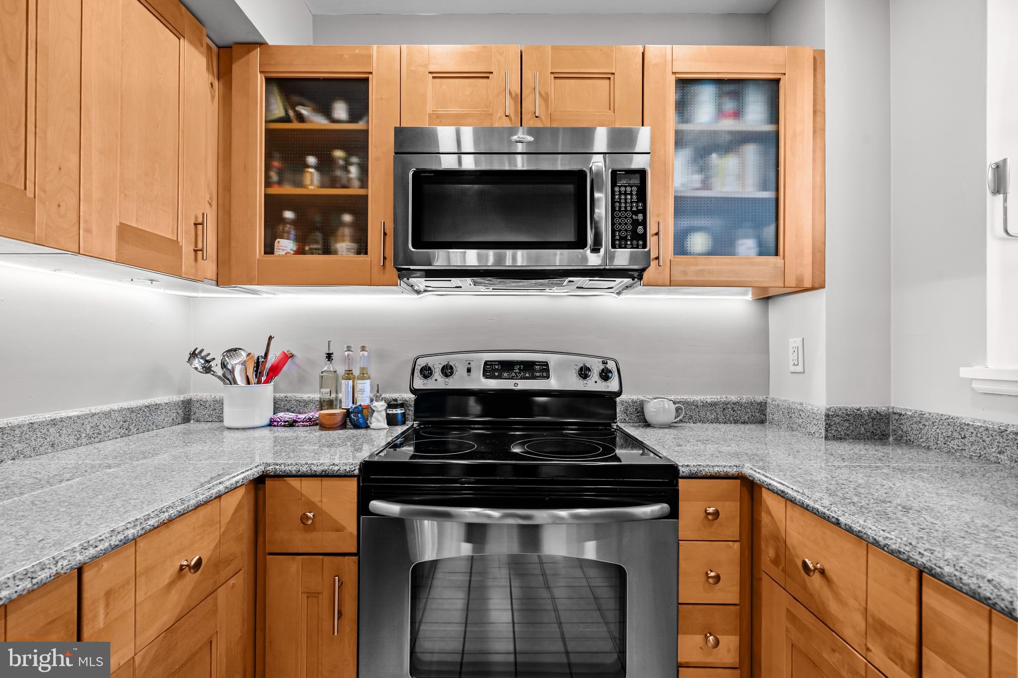 3861 Porter Street Northwest, Unit C285 Washington, DC 20016 - Photo 10 of 23 a kitchen with granite countertop stainless steel appliances a stove and a sink