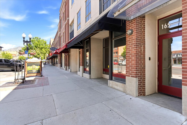 161 25th Street, Unit 6B Ogden, UT 84401 - Photo 2 of 20 Commercial storefront featuring a red door with glass panels, brick facade elements, and a black awning