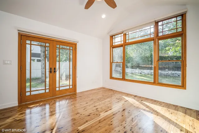 a view of an empty room with a window and wooden floor