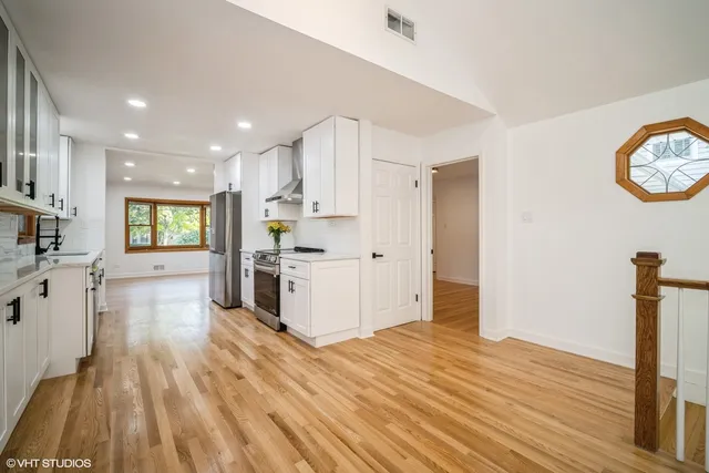 a kitchen with a refrigerator and a stove top oven