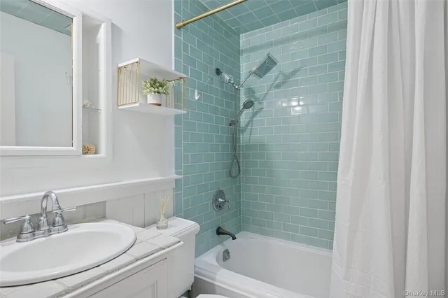 a bathroom with a bathtub shower sink vanity and toilet