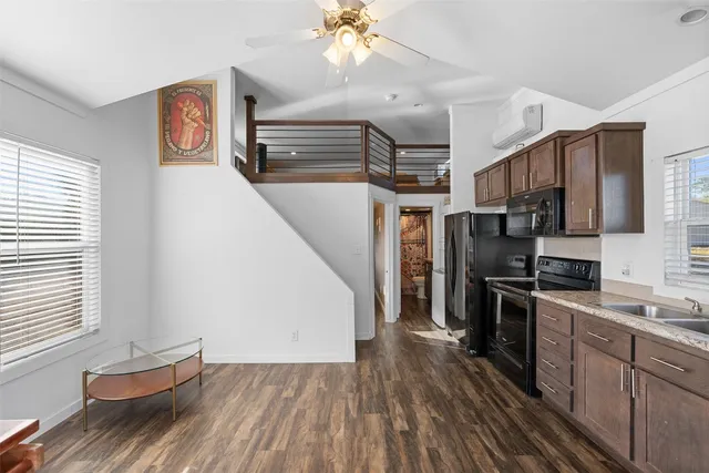 a kitchen with stainless steel appliances granite countertop a refrigerator a sink dishwasher a stove and white countertops with wooden floor