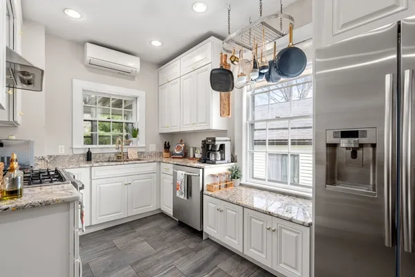 a kitchen with cabinets stainless steel appliances and a window