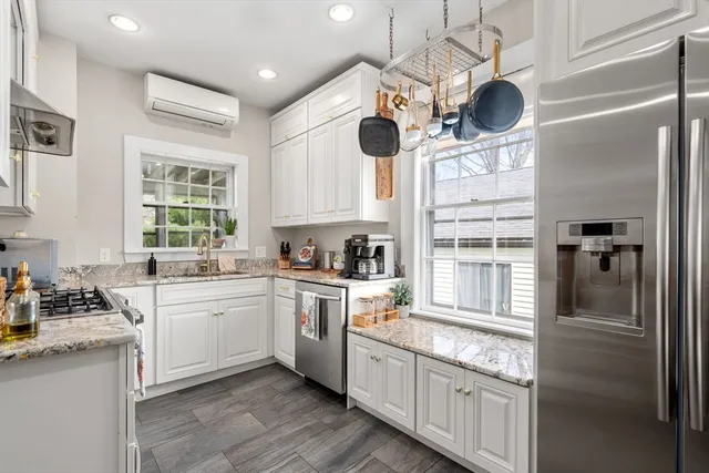 a kitchen with cabinets stainless steel appliances and a window