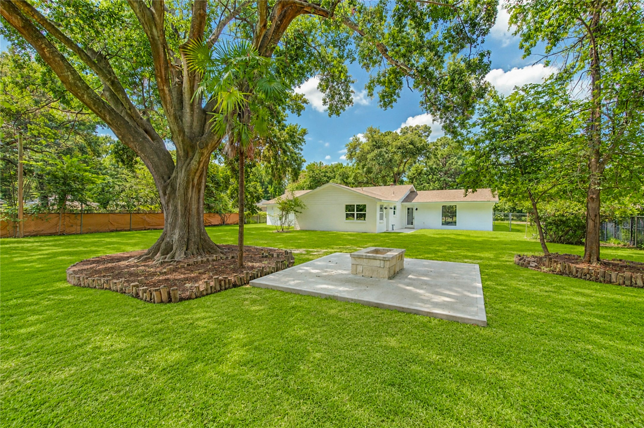 5411 Logston Lane Spring, TX 77389 - Photo 50 of 50 Expansive backyard with lush greenery, mature trees, and a spacious patio area, perfect for outdoor gatherings and relaxation.