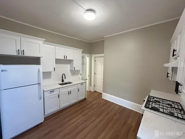 a kitchen with sink cabinets and wooden floor