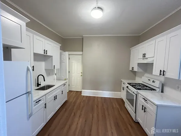 a kitchen with granite countertop a sink stove and cabinets