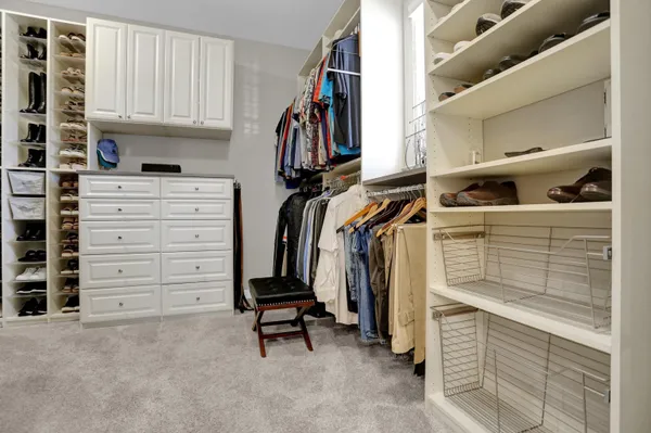 a view of walk in closet with clothes