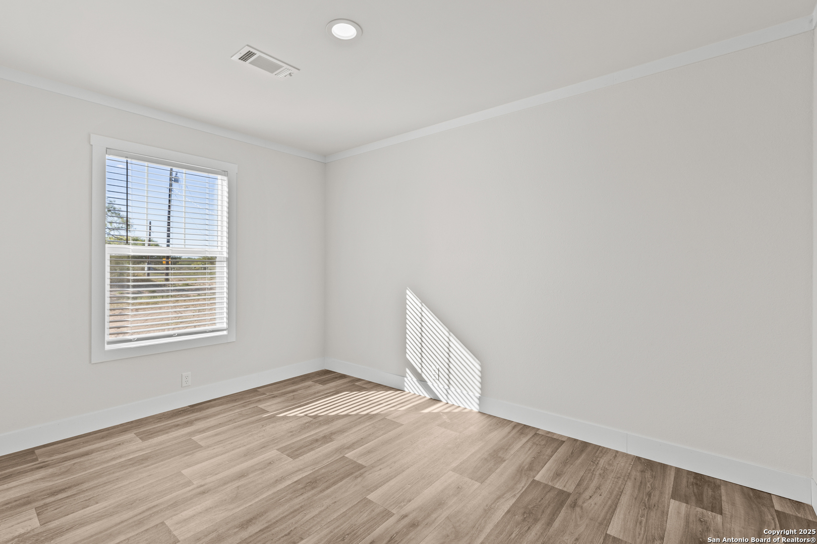 2354 Stevens Road Somerset, TX 78069 - Photo 16 of 22 an empty room with wooden floor and windows