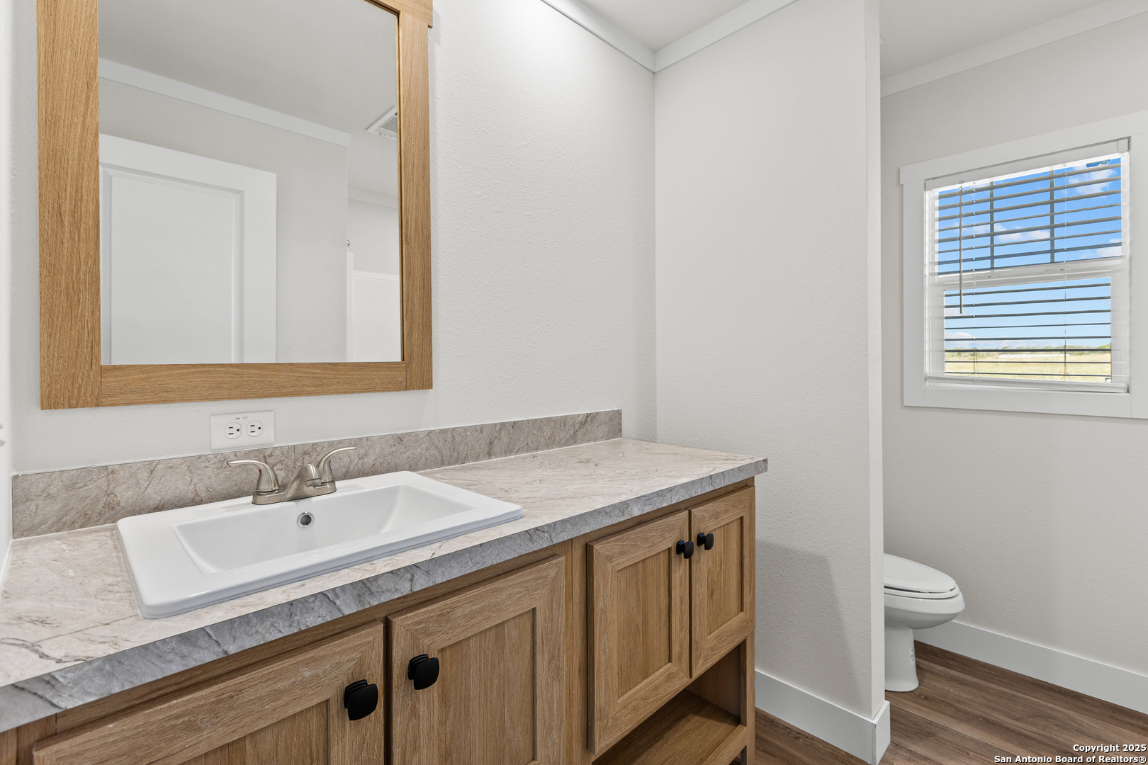2354 Stevens Road Somerset, TX 78069 - Photo 19 of 22 a bathroom with a granite countertop sink a toilet and a mirror
