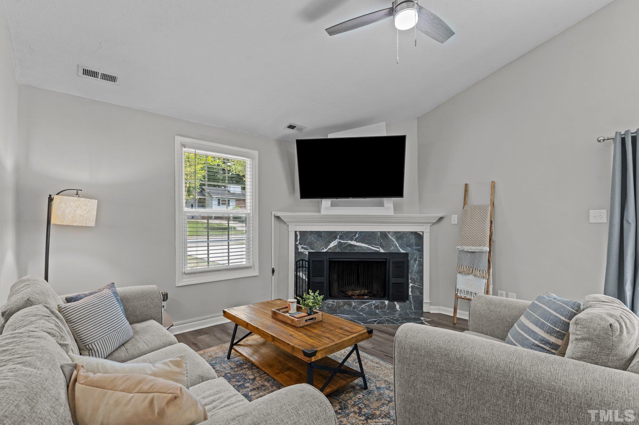 3717 Summer Place Raleigh, NC 27604 - Photo 3 of 26 a living room with furniture a fireplace and a flat screen tv