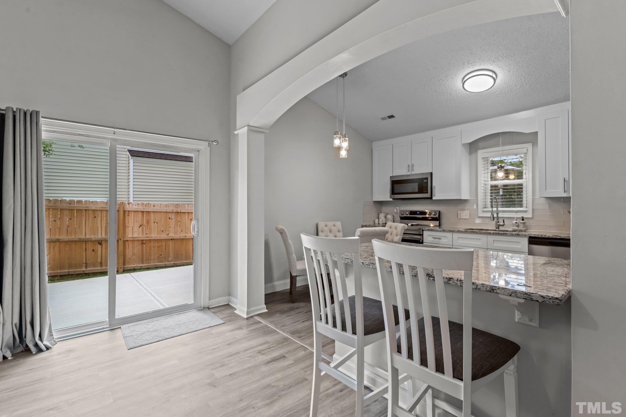 3717 Summer Place Raleigh, NC 27604 - Photo 7 of 26 a kitchen with stainless steel appliances granite countertop a stove top oven a sink a dining table and chairs