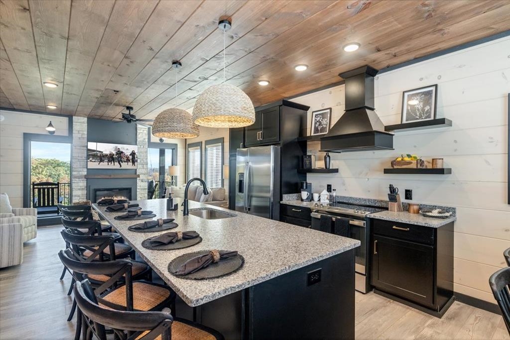288 Rambling Creek Way, Unit LOT 79R Sevierville, TN 37862 - Photo 25 of 40 a kitchen with stainless steel appliances granite countertop a stove a sink dishwasher a dining table and chairs with wooden cabinets