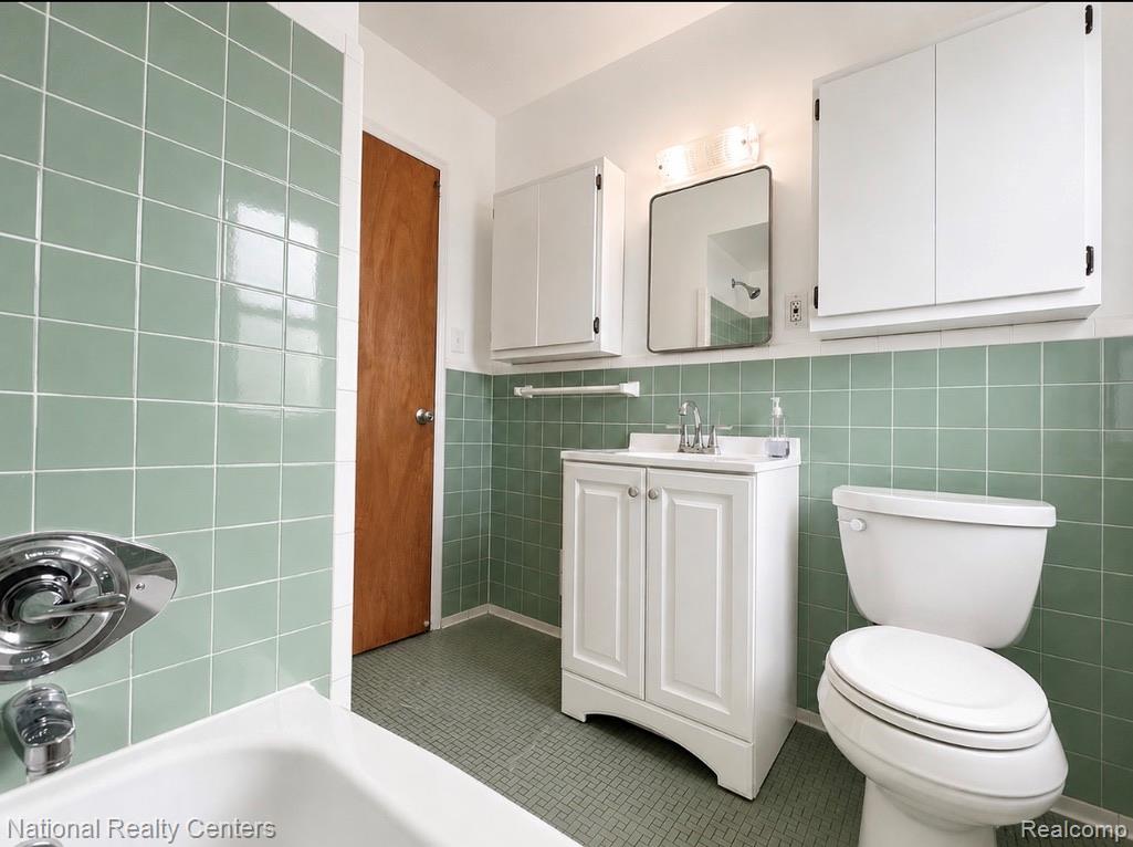 7285 Helen Street Center Line, MI 48015 - Photo 16 of 32 Bathroom featuring a white vanity with integrated sink, chrome faucet, and a large mirror