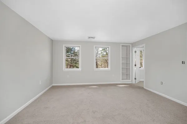 an empty room with a window and a fan