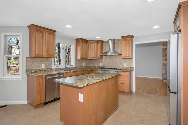 a kitchen with stainless steel appliances granite countertop a refrigerator and a stove top oven