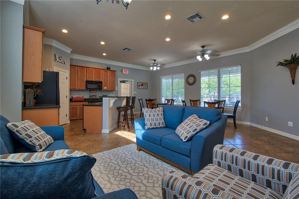 1900 Scofield Ridge Parkway, Unit 5501 Austin, TX 78727 - Photo 12 of 21 A community space featuring a kitchen with a breakfast bar, and a living area with ample seating, perfect for gatherings.