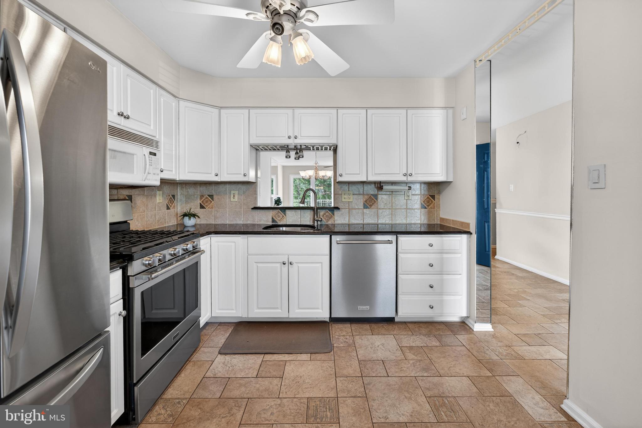 7401A Normandy Drive Mount Laurel, NJ 08054 - Photo 6 of 35 a kitchen with stainless steel appliances granite countertop a stove a sink and a refrigerator