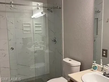 a bathroom with a shower a toilet and a sink