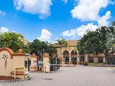 a front view of a building with streets and trees